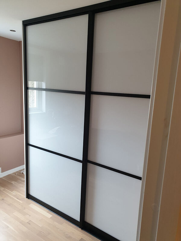 skyvedørsgarderobe med hvitt glass og svarte profiler og sprosser i new york loft stil