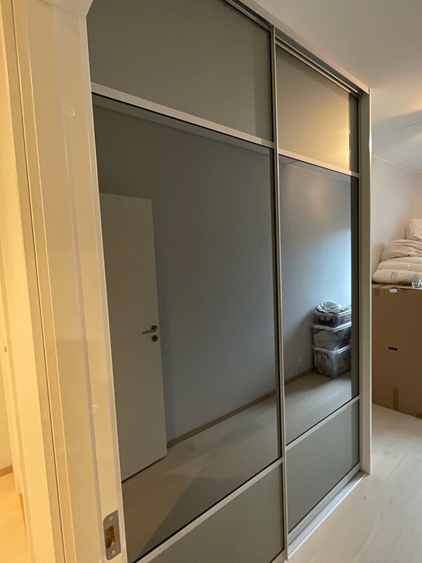 skyvedører med grått glass og sotet speil, og sølvfargede profiler og sprosser