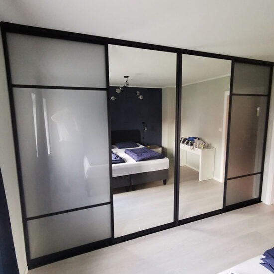 stor skyvedørsgarderobe med fire skyvedører med glass og speil