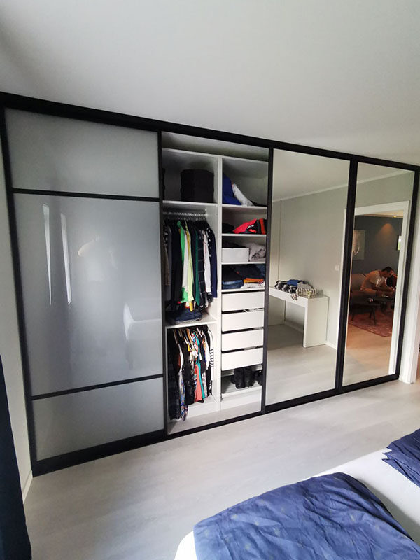 stor skyvedørsgarderobe med fire skyvedører med glass og speil