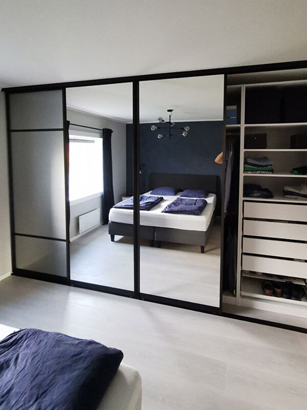 stor skyvedørsgarderobe med fire skyvedører med glass og speil
