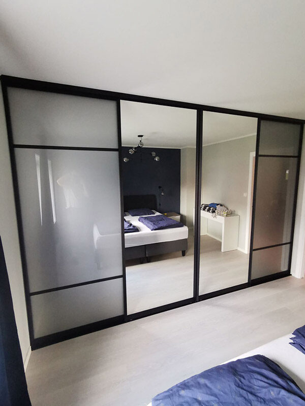stor skyvedørsgarderobe med fire skyvedører med glass og speil
