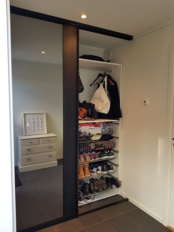 Skyvedørsgarderoben med speil helt ned til gulvet får den lille gangen til Ingeborg til å fremstå som større og mer romslig. Og plassen utnyttes maksimalt med smart innredning. Les mer på garderobemekka.no