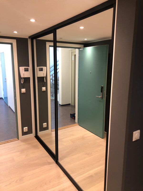 skyvedørsgarderobe med store skyvedører med speil og svarte profiler skreddersydd på mål