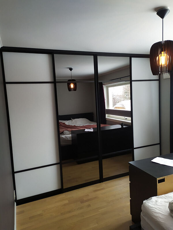 skyvedører med hvitt glass og sotet speil, og med svarte profiler og sprosser som dekor